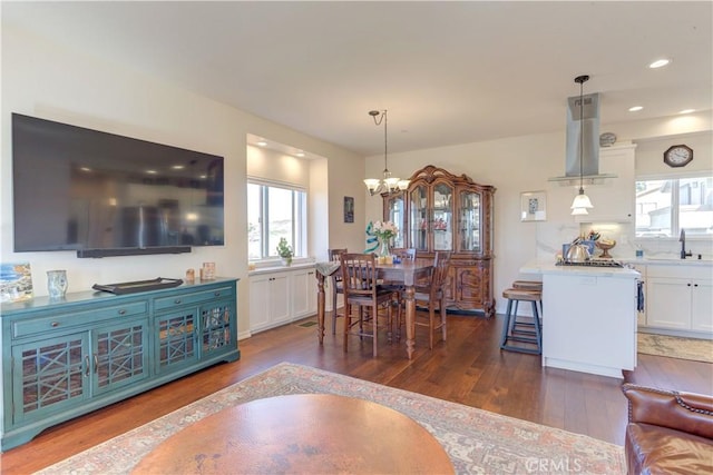 dining room featuring dark hardwood / wood-style floors, sink, and a notable chandelier