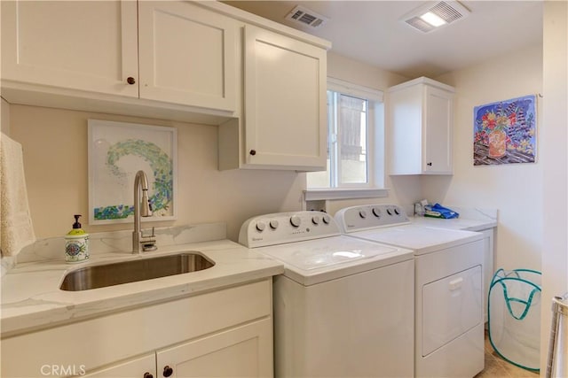 washroom with washer and dryer, sink, and cabinets