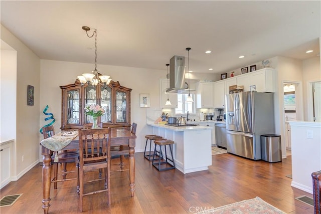 dining space with an inviting chandelier, dark hardwood / wood-style flooring, and sink