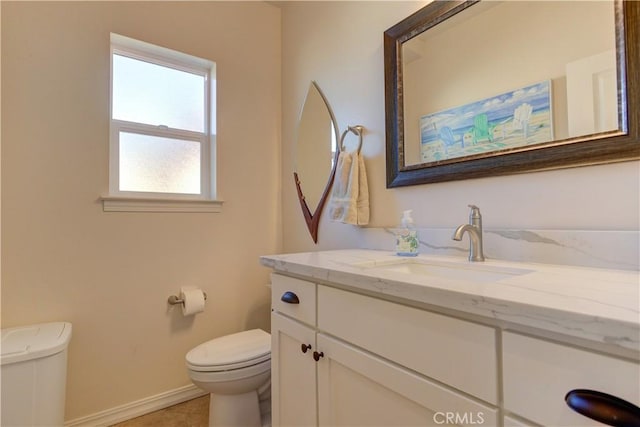 bathroom with toilet, tile patterned flooring, and vanity