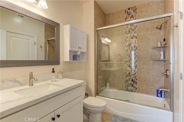 full bathroom with combined bath / shower with glass door, vanity, and toilet