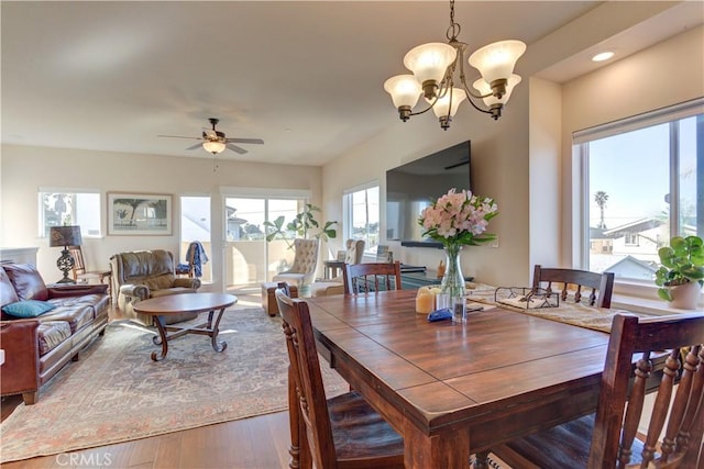 dining room featuring wood-type flooring and ceiling fan with notable chandelier