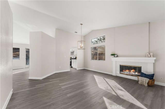 unfurnished living room featuring lofted ceiling, dark wood-type flooring, and a tile fireplace