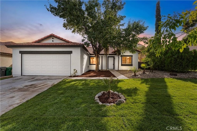 mediterranean / spanish home with a garage and a lawn