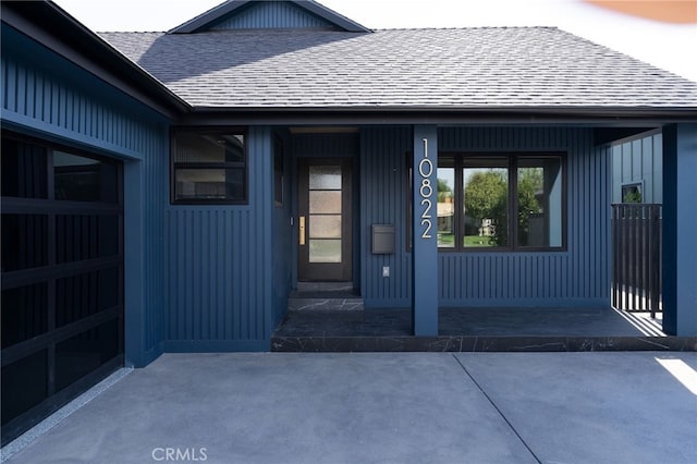 doorway to property with a shingled roof and a porch