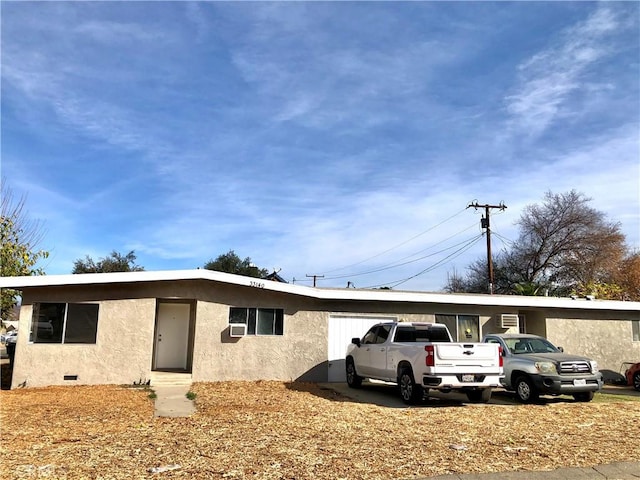 view of front of property with crawl space, an attached garage, and stucco siding