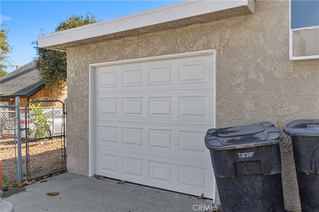 garage with a gate and fence