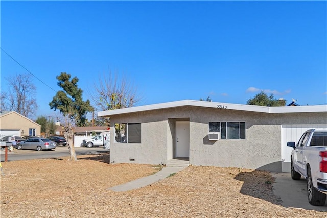 view of front of property with crawl space, cooling unit, and stucco siding