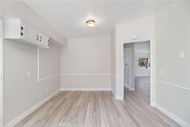 spare room with light wood-type flooring and baseboards