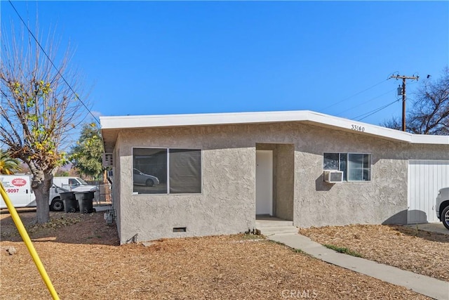 view of front of home with crawl space, cooling unit, and stucco siding