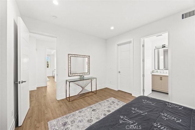 bedroom featuring sink, hardwood / wood-style flooring, and ensuite bath