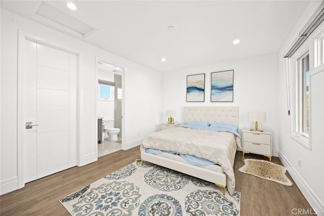 bedroom featuring hardwood / wood-style floors and ensuite bath