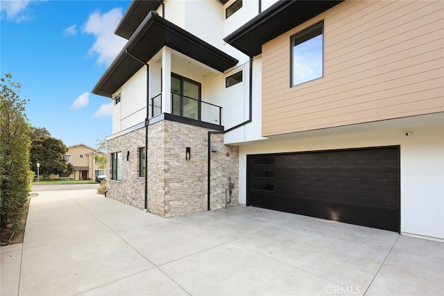 view of home's exterior with a garage and a balcony