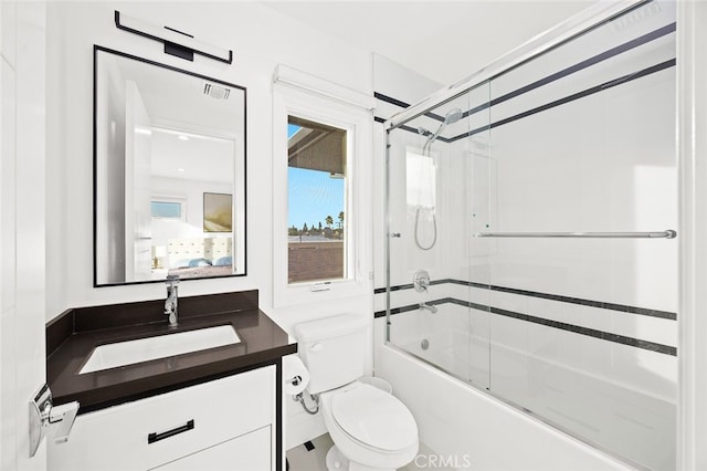 full bathroom with toilet, bath / shower combo with glass door, and vanity