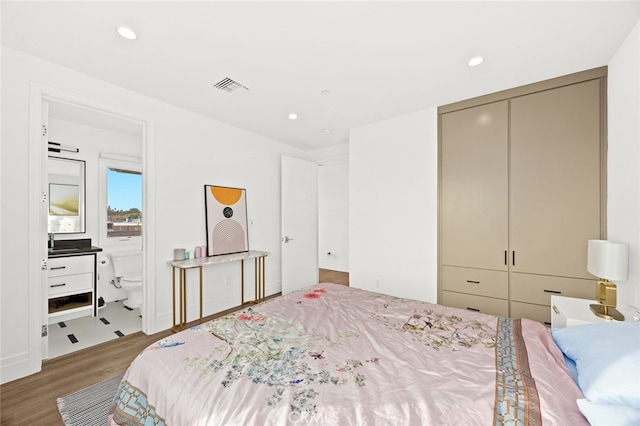 bedroom with a closet and hardwood / wood-style flooring