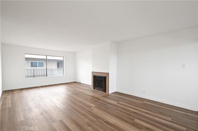 unfurnished living room featuring a fireplace and dark wood-type flooring