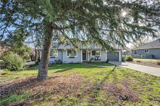 single story home featuring a garage and a front yard