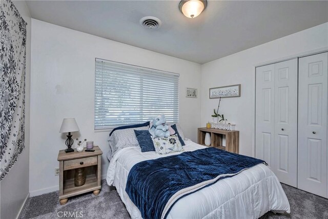 bedroom with a closet and dark colored carpet