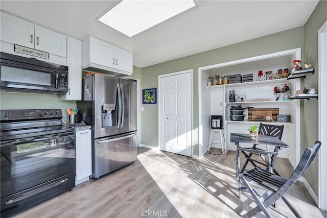 kitchen with white cabinetry, light hardwood / wood-style floors, and black appliances