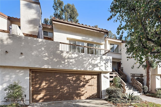 view of front of home featuring a garage and a balcony