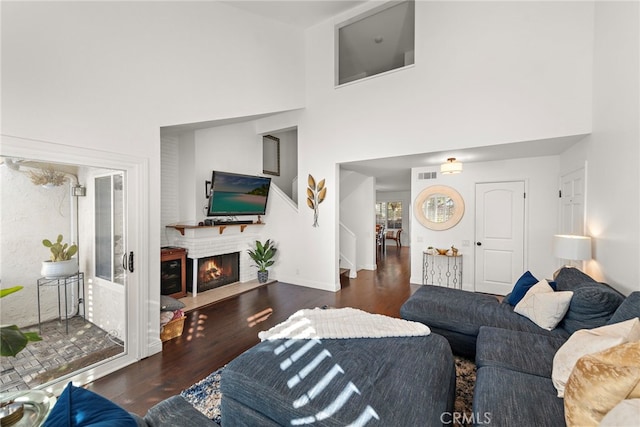 living room with dark hardwood / wood-style flooring and a towering ceiling