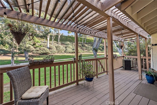 wooden deck with a lawn and a pergola