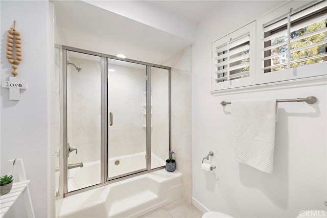 bathroom with combined bath / shower with glass door and tile patterned floors