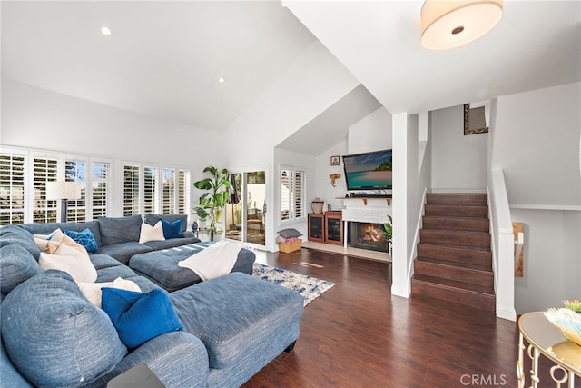 living room with dark wood-type flooring and high vaulted ceiling