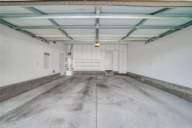 garage with a garage door opener, strapped water heater, and electric panel