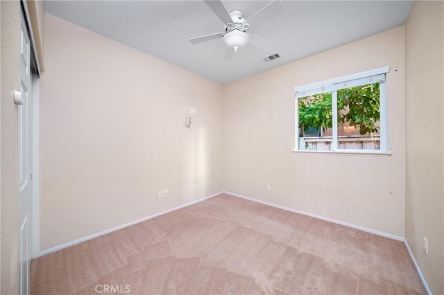 carpeted spare room featuring ceiling fan