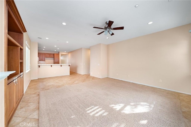 unfurnished living room with ceiling fan and light tile patterned floors