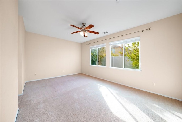 empty room featuring ceiling fan and light colored carpet