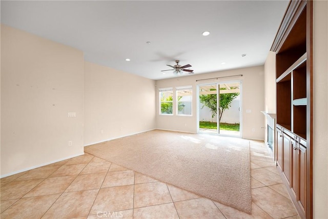 unfurnished living room featuring ceiling fan and light tile patterned flooring