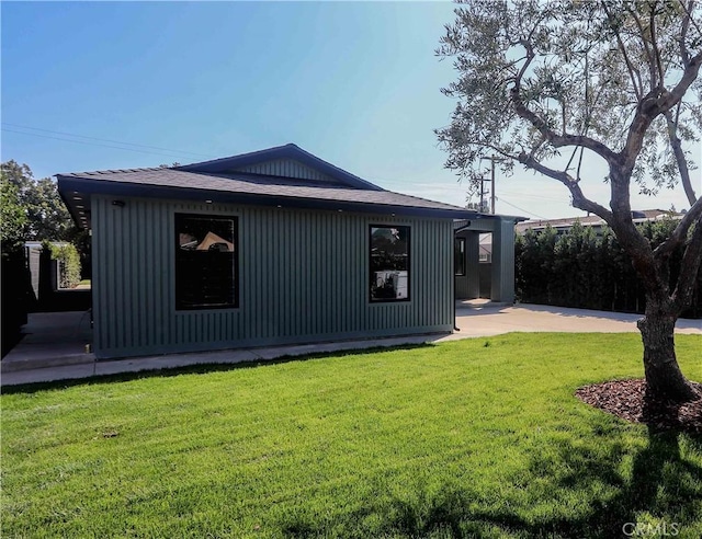 view of side of home with a patio and a lawn