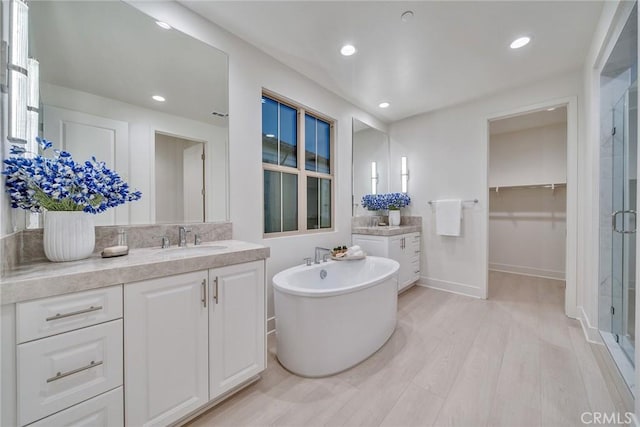 bathroom with vanity and shower with separate bathtub