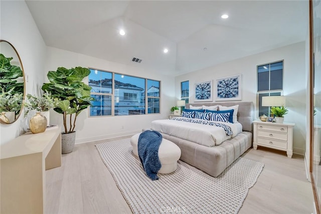 bedroom featuring light hardwood / wood-style floors and lofted ceiling