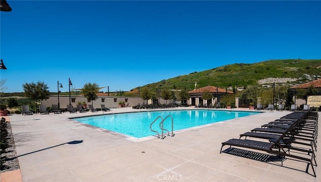 view of pool with a mountain view and a patio area