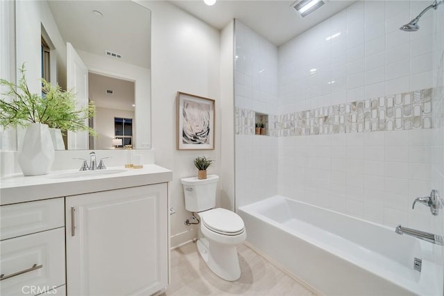 full bathroom featuring toilet, tiled shower / bath, and vanity