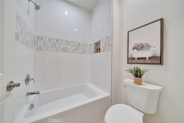 bathroom with tiled shower / bath combo and toilet