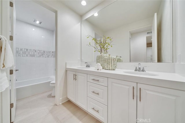 full bathroom featuring toilet, vanity, and tiled shower / bath combo