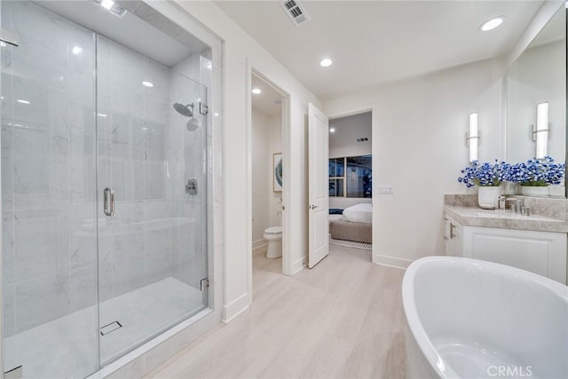 full bathroom with toilet, hardwood / wood-style floors, separate shower and tub, and vanity