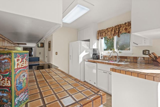 kitchen featuring white cabinetry, sink, tile counters, and white appliances