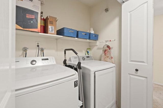 clothes washing area with light colored carpet and washer and dryer