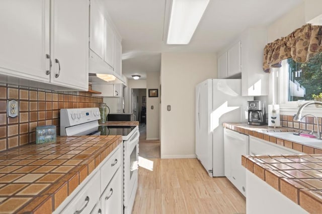 kitchen with white appliances, tile counters, and white cabinets