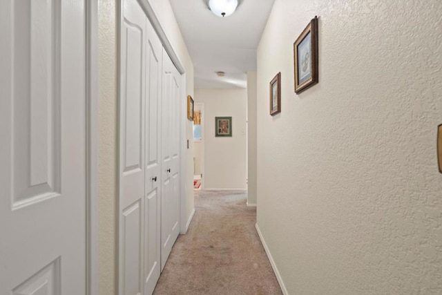 corridor featuring light colored carpet