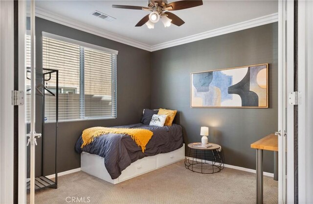 carpeted bedroom featuring ceiling fan and crown molding