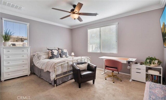 carpeted bedroom with ceiling fan, ornamental molding, and multiple windows