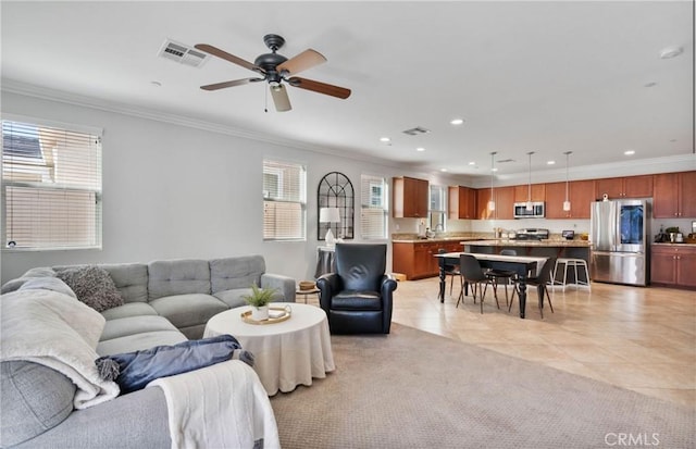 tiled living room with ceiling fan, a healthy amount of sunlight, and ornamental molding