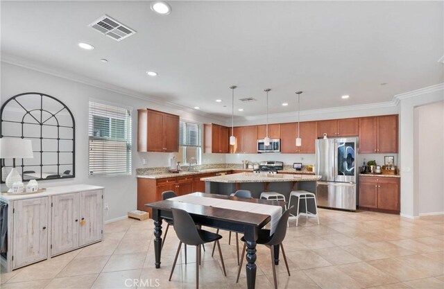 kitchen with stainless steel appliances, pendant lighting, light stone countertops, crown molding, and a center island