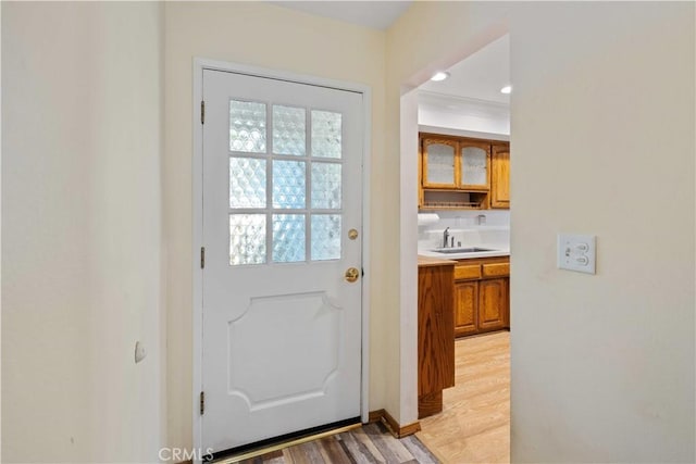 doorway to outside featuring sink and light hardwood / wood-style flooring